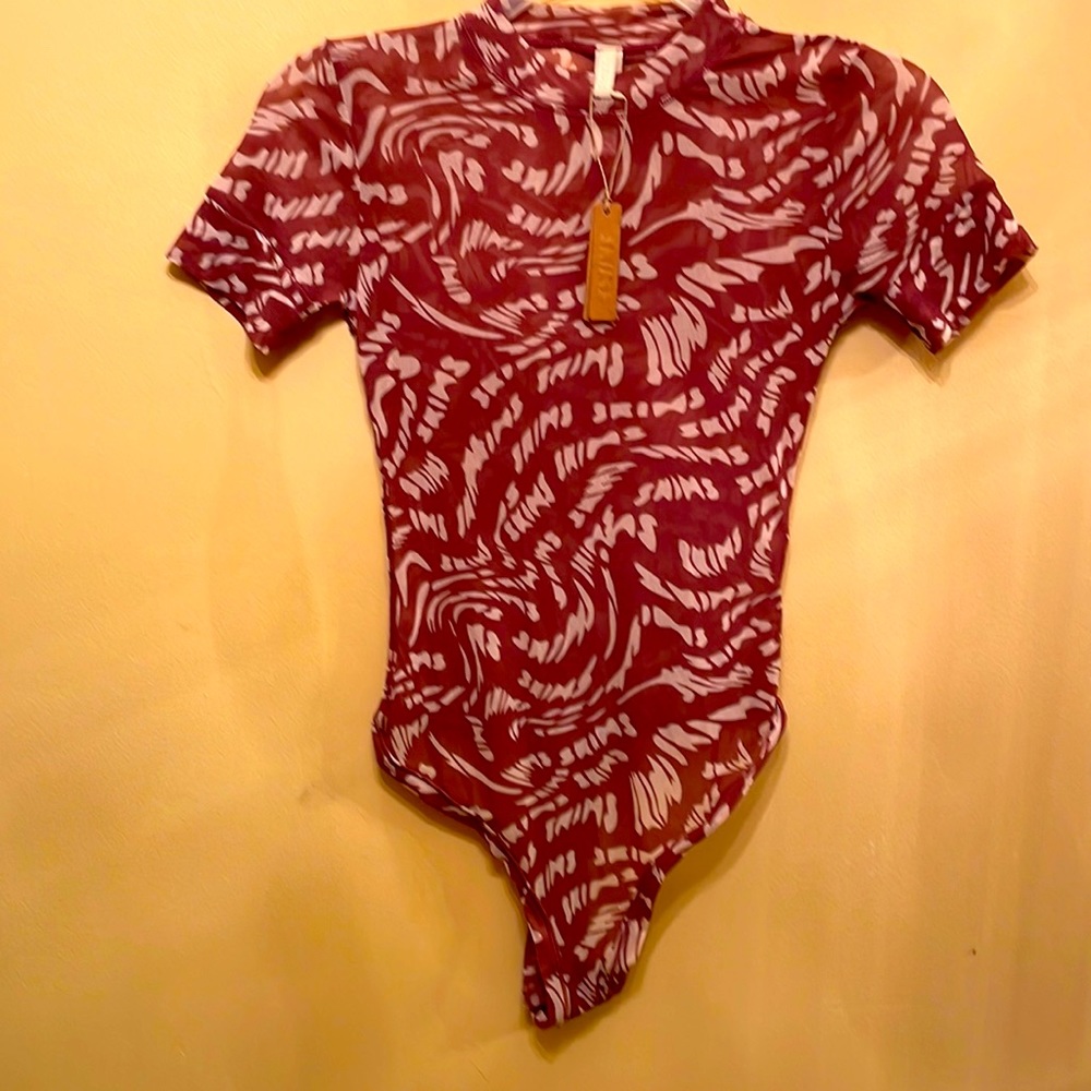 Skims medium bodysuit in a light purple and cream lightweight material.